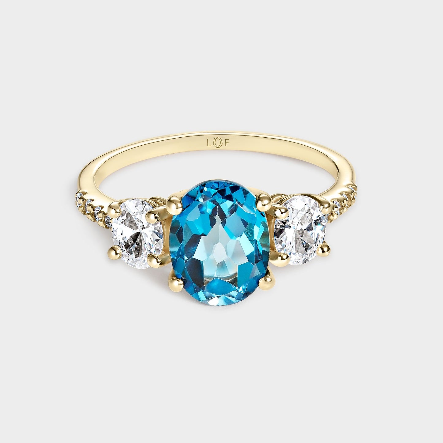 ANILLO TRILOGÍA TOPACIO LONDON 9*7 Y TOPACIOS BLANCOS 5*4 CON CIRCONITAS
EN ORO DE 18 QUILATES.