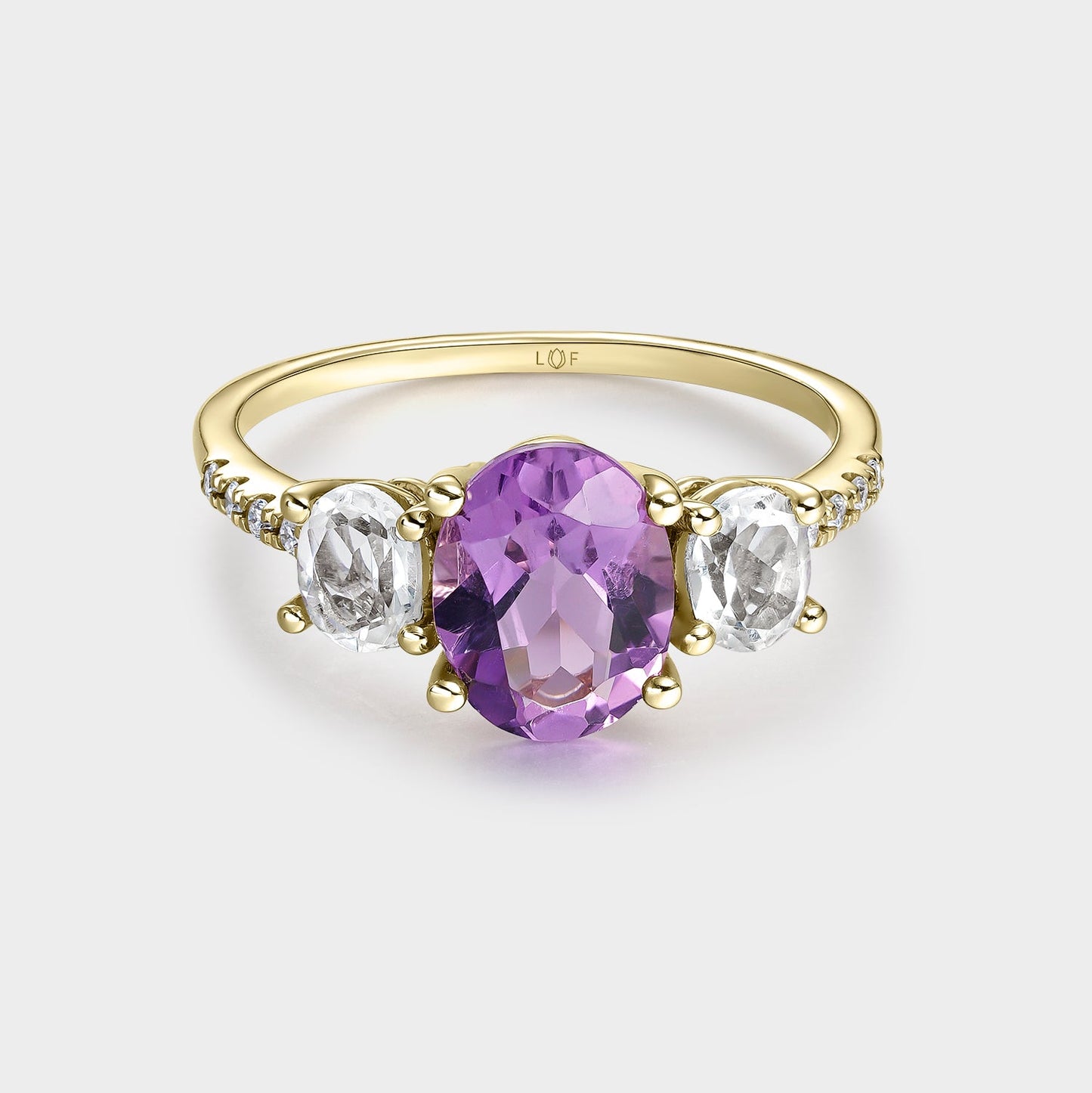 Anillo trilogía amatista 9*7 y amatistas verde 5*4 con circonitas
en oro de 18 quilates.