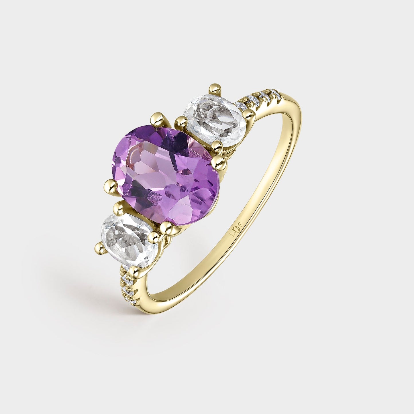 Anillo trilogía amatista 9*7 y amatistas verde 5*4 con circonitas
en oro de 18 quilates.
