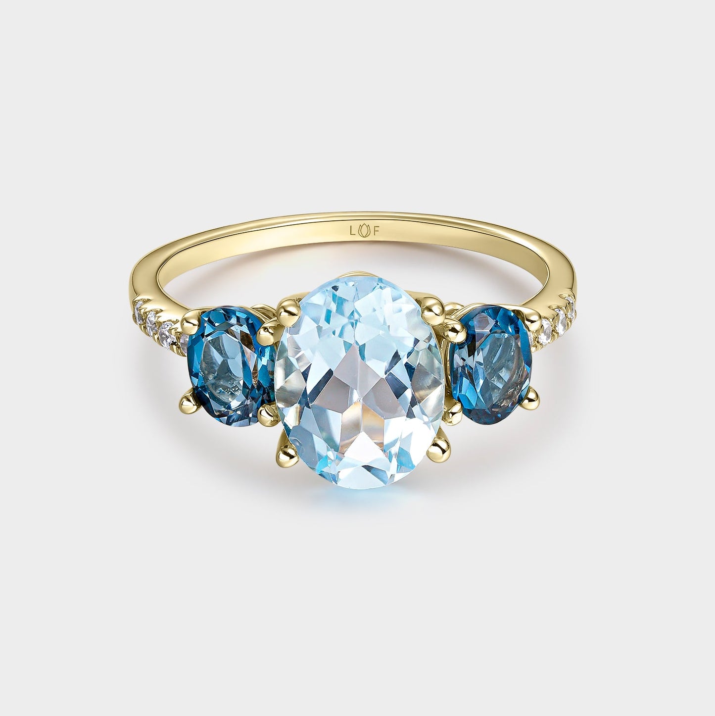 Anillo trilogía topacio 9*7 y topacios london 5*4 con circonitas
en oro de 18 quilates.