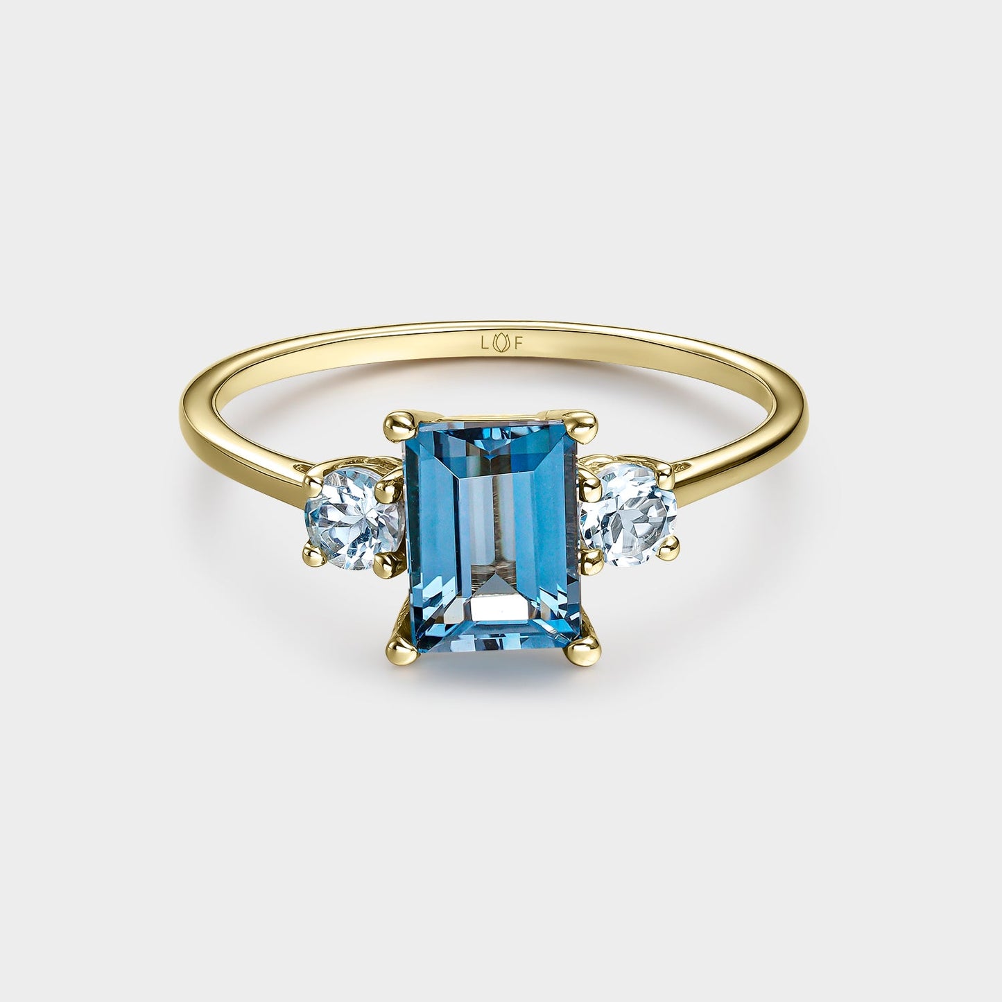 Anillo trilogía topacio london octogonal 7*5 y topacios blancos 3mm con circonitas
en oro de 18 quilates.